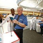 In this photo provided by Nintendo of America Inc., Nintendo brand ambassador Adrienne Dawkins from [CITY, STATE] demonstrates the portable Nintendo 3DS system to JetBlue pilot Vincent Quinn from Goldsboro, N.C. at New York’s John F. Kennedy International Airport on April 22, 2011. Now through May 30, customers who visit JetBlue’s award-winning Terminal 5 at the airport will have access to an interactive Nintendo 3DS grandstand where they can play games, enjoy 3D photos and participate in daily prize giveaways. (Anders Krusberg for Nintendo of America)