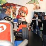 In this photo provided by Nintendo of America, Ryan Friedlinghaus, founder and CEO of West Coast Customs (R) points out key features of the life-size Mario Kart to Reggie Fils-Aime, president and COO of Nintendo of America (L), at the LA Auto Show, Thursday, Nov. 17, 2011 in Los Angeles. Nintendo teamed up with West Coast Customs to create two vehicles in celebration of the Dec. 4 release of Mario Kart 7 for the portable Nintendo 3DS system. (AP Photo/Nintendo, Bob Riha, Jr.) No Sales
