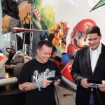 In this photo provided by Nintendo of America, Reggie Fils-Aime, president and COO of Nintendo of America (R), and Ryan Friedlinghaus, founder and CEO of West Coast Customs, play Mario Kart 7 for the portable Nintendo 3DS system at the LA Auto Show on Nov. 17, 2011 in Los Angeles. Nintendo made its first-ever appearance at an automotive trade show to unveil life-size models of two Mario Kart-themed vehicles. (AP Photo/Nintendo, Bob Riha, Jr.) No Sales