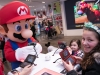In this photo provided by Nintendo of America, Gia P. from Bronx, NY and Alyssa P. from Bronx, NY meet with Mario at the Nintendo NY store in Rockefeller Plaza on Friday, March 24. Fans gathered to celebrate the launch of Mario Sports Superstars, an action-packed Nintendo 3DS game that finds players competing in five full-featured sports: Baseball, Soccer, Golf, Tennis and Horse Racing.